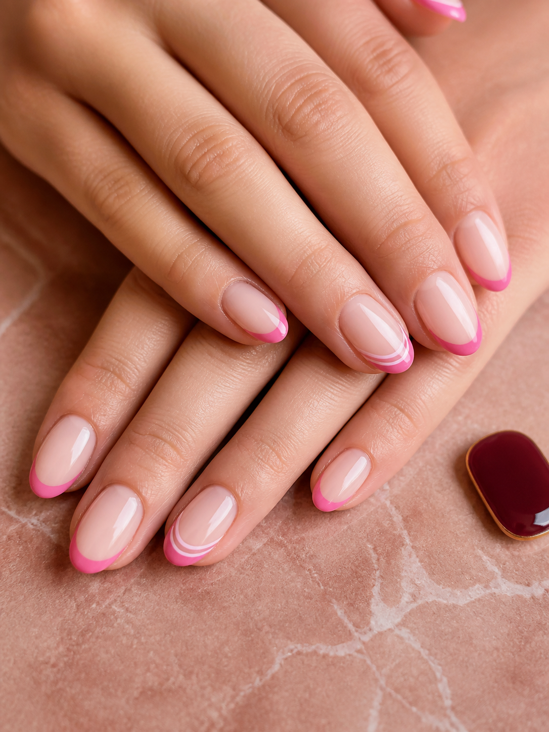 Blush manicure with precise raspberry French tips